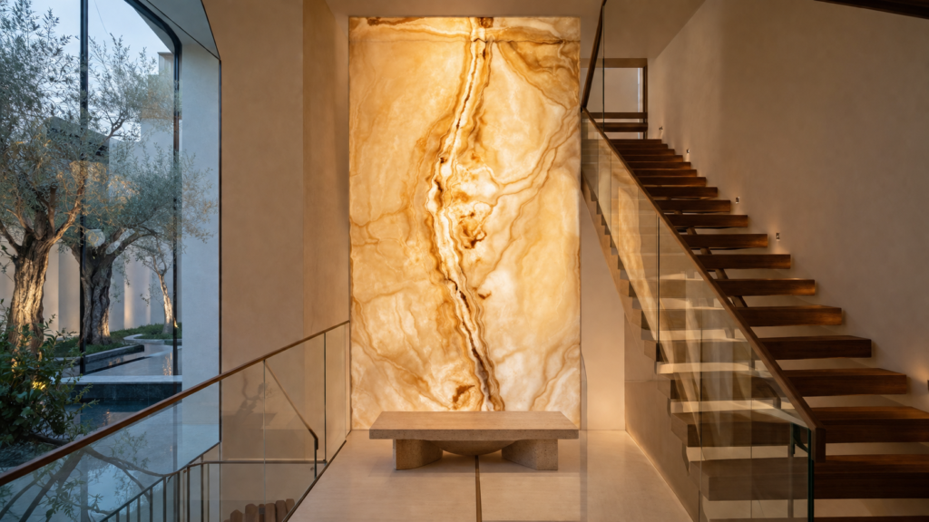 Backlit natural onyx feature panel creating a luxurious staircase landing focal point.