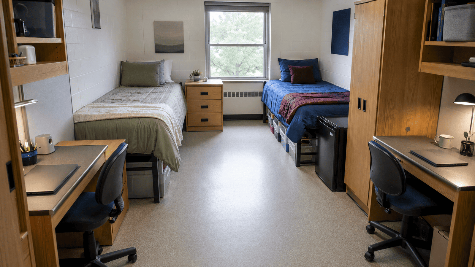 Shared college dorm room arranged with two beds, desks, storage, and a clear walking path