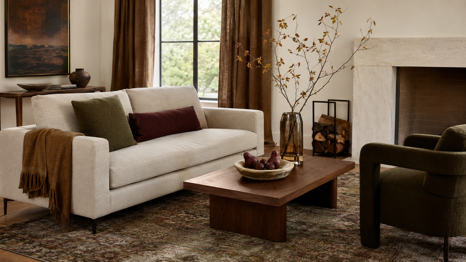 Cozy fall living room with warm layered textiles, walnut furniture, olive accents, and natural branches.